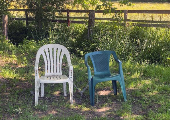 News Bilder des Tages 25.05.2026, Deutschland, NRW, Freizeit, Erholung, Zusammengekettete Kunststoffstühle auf einer Wiese, Stühle, Plastikstuhl, Stuhl mit Armlehnen, Deutschland Copyright: xD.xKerlekin SnowfieldxPhotographyx SF250526StuehleD