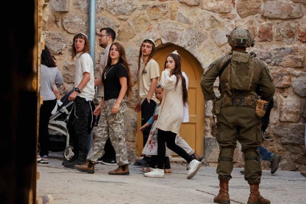 Hebron Israeli Settlers Tour May 23 An armed Israeli soldier stands guard while Israeli settlers continue their tour in the Old City of Hebron, in the occupied West Bank, on May 23, 2026. The area is routinely secured by military forces to escort settlers touring the city, amid ongoing tensions regarding settlement expansion near the Ibrahimi Mosque. Hebron West Bank Palestinian Territories Copyright: xMosabxShawerx