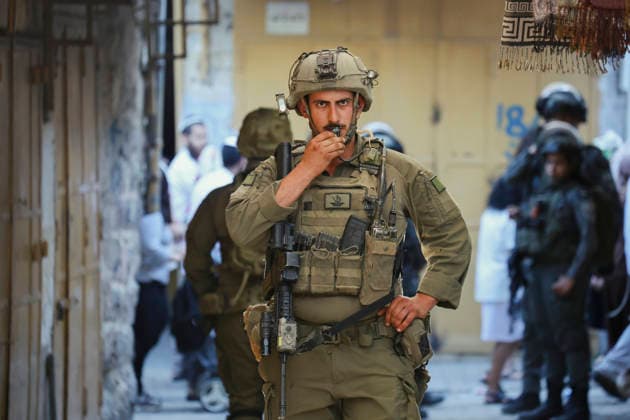 Hebron Israeli Settlers Tour May 23 An armed Israeli soldier uses a radio while standing in an alleyway in the Old City of Hebron, in the occupied West Bank, on May 23, 2026. The area is routinely secured by military forces to escort settlers touring the city, amid ongoing tensions regarding settlement expansion near the Ibrahimi Mosque. Hebron West Bank Palestinian Territories Copyright: xMosabxShawerx