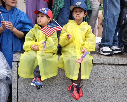 May 25, 2026, Washington, District Of Columbia, USA: Young attendees holding American flags watch the National Memorial Day Parade in Washington. The parade has been held annually since 2005, marking its 21st anniversary. Washington USA  - ZUMAs337 20260525_znp_s337_023 Copyright: xGentxShkullakux