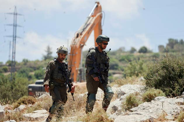 Israeli Demolition West Bank Family Displaced Eid Al-Adha Armed Israeli soldiers walk near a demolition excavator in Nahhalin, occupied West Bank, on May 25, 2026, after an operation. The demolition, carried out by Israeli forces who stated the structure was built without a permit, displaced an eight-member Palestinian family just two days before the Islamic holiday of Eid al-Adha. Bethlehem West Bank Palestinian Territories Copyright: xMosabxShawerx