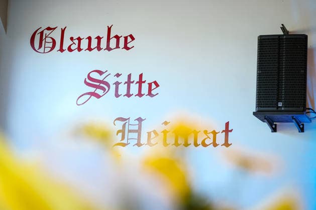 27.05.2026, Politik, Bundeskanzler Friedrich Merz (CDU) zu Gast als Festredner beim Festakt in der Schützenhalle Hüsten bei Arnsberg. 80 Jahre Neheim-Hüstener Programm. Wandaufschrift Schriftzug Glaube Sitte Heimat Nordrhein-Westfalen Deutschland