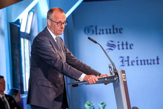 27.05.2026, Politik, Bundeskanzler Friedrich Merz (CDU) Spricht auf der Bühne bei seiner Rede zu Gast als Festredner beim Festakt in der Schützenhalle Hüsten bei Arnsberg. 80 Jahre Neheim-Hüstener Programm. Glaube Sitte Heimat Schriftzug Nordrhein-Westfalen Deutschland