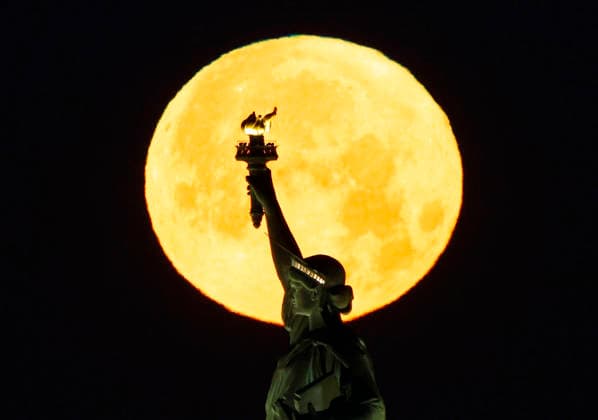 A rare Blue Moon, the second full moon to appear in the sky in a single month, sets behind the Statue of Liberty on Sunday, May 31, 2026 in New York City.  NYP20260531102 JOHNxANGELILLO