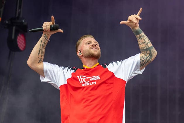 Musikfestival Rock im Park 2026 - FINCH, Nürnberg, 06.06.2026 Rapper Finch bei seinem Auftritt auf der Buehne. Er traegt ein Trikot des 1. FC Union Berlin und haelt das Mikrofon mit ausgestreckten Armen in die Hoehe. Nürnberg Bayern Deutschland