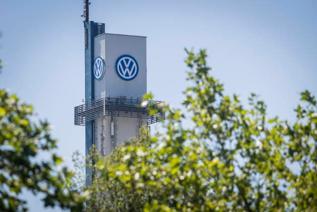 Turm vom VW-Werk in Osnabrück mit VW Logo bei blauem Himmel, vom Laub grüner Bäume umrahmt. Symbolbild Volkswagen Osnabrück. 11.07.2026 Symbolbild VW Osnabrück