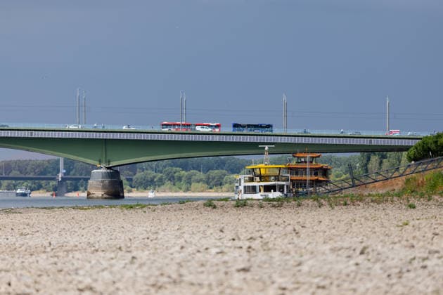Niedrigwasser am Rhein in Bonn-Beuel Niedrigwasser am Rhein: Bei einem Pegelstand von 125 cm am Pegel Bonn liegt das Flussbett am Beueler Rheinufer bis auf die tiefer liegende Fahrrinne trocken. Blick nach Norden auf die stark befahrene Kennedybrücke, im Hintergrund die gesperrte Nordbrücke (Friedrich-Ebert-Brücke). Bonn Beuel Nordrhein-Westfalen Deutschland Copyright: xMarcxJohnx