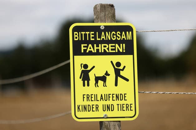 Ein Schild an einer Strasse (Straße) bei einem Pferdehof in Siegen-Oberschelden mit der Aufschrift BITTE LANGSAM FAHREN! FREILAUFENDE KINDER UND TIERE. Verkehrswesen im Siegerland am 24.07.2026 in Siegen Deutschland.