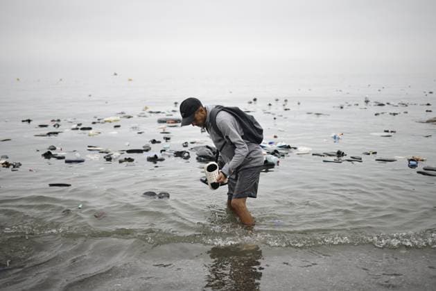 Ceuta wakes up to a steady stream of people from Morocco and thousands of young people wandering the streets. A man picks up a pair of flip-flops from the water, on July 31, 2026, in Ceuta, Spain. The autonomous city of Ceuta awoke to a steady stream of people continuing to enter from Morocco early this morning, following a night in which the influx through the border area never ceased. Thousands of migrants have entered the autonomous city today by swimming and also on on foot along the breakwater that separates the autonomous city from Morocco. Police sources indicate that more than 20,000 people have entered Spain. JULY 31, 2026. Jesú, Ceuta, Ceuta, Spain Copyright: xJesusxTorresx 7697092