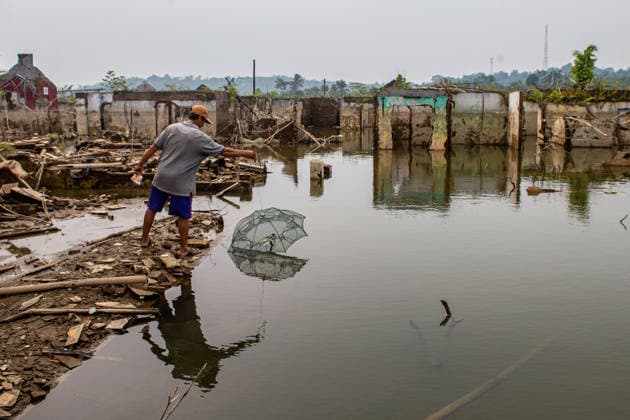 July 31, 2026, Lebak Regency, Banten, Indonesia: A man casts a fishing net as he walks through the ruins of Somang village, which has re-emerged as water levels recede during the dry season, amid forecasts that El Nio±o may contribute to drier-than-normal conditions, at Karian Reservoir in Sajira district, Lebak Regency, Banten province, Indonesia, July 31, 2026. Lebak Regency Indonesia - ZUMAp283 20260731_zip_p283_015 Copyright: xClaudioxPramanax