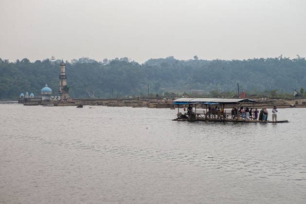 July 31, 2026, Lebak Regency, Banten, Indonesia: A bamboo raft carrying tourists passes through the ruins of Somang village, which have re-emerged as water levels recede during the dry season, amid forecasts that El Nio±o may contribute to drier-than-normal conditions, at Karian Reservoir in Sajira district, Lebak Regency, Banten province, Indonesia, July 31, 2026. Lebak Regency Indonesia - ZUMAp283 20260731_zip_p283_022 Copyright: xClaudioxPramanax