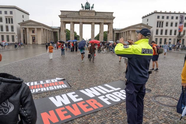 We will never forget, 82. Jahrestag des Warschauer Aufstands, spektakuläre Protestaktion von polnischen Aktivisten, sie erinnern an die Tausenden 1944 ermordeten Kinder, Polizist dokumentiert die Szene nach Ende der Aktion, Berlin, 1. August 2026 Deutschland, Berlin, 1. August 2026, We will never forget, ein Berliner Polizist dokumentiert das zurückgelassene Transparent nach dem Ende der spektakulären Protestaktion polnischer Aktivisten, die an die Tausenden ermordeten Kinder erinnert hatten, Samstag um 14:15 Uhr, die Protestaktion dauerte nur 5 Minuten, Aktion zum 82. Jahrestag des Warschauer Aufstands heute am 1. August, Drittes Reich, Terror, Nationalsozialismus, Nationalsozialisten, Geschichte, Politik,