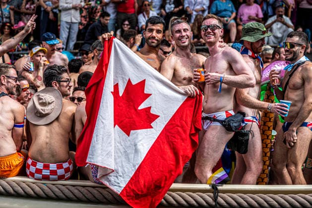 August 1, 2026, Amsterdam, North Holland, Netherlands: A Canal Parade participant displays a Canadian flag. August 1, 2026, Amsterdam, the Netherlands. Hundreds of thousands of spectators joined the 30th edition of the Pride Canal Parade, the highlight of WorldPride Amsterdam 2026. This yearâ€⠢s parade also included the WorldPride Stadium grandstand, with seating for approximately 10,000 people to watch as floats pass. Amsterdam Netherlands - ZUMAp202 20260801_zip_p202_047 Copyright: xJamesxPetermeierx