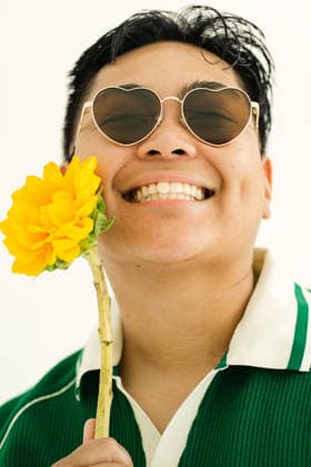 Cheerful person wearing heart sunglasses holds a sunflower Baltimore, Maryland, United States CR_WIXS260731-2080219-01 ,model released, Symbolfoto ,property released