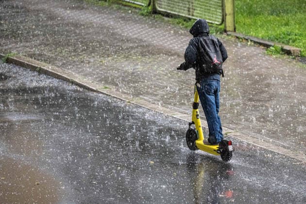 Starkregen in Göttingen 03.08.2026, Göttingen --- Ein Mann fährt während eines Starkregens mit einem E-Scooter durch Göttingen. Göttingen Niedersachsen Deutschland