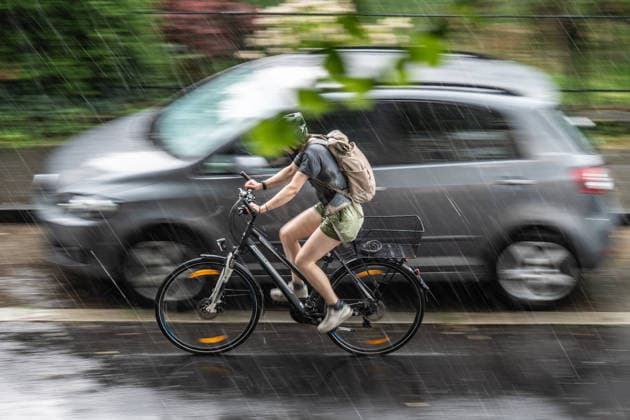 Starkregen in Göttingen 03.08.2026, Göttingen --- Eine Radfahrerin fährt während eines Starkregens durch eine Straße in Göttingen. Göttingen Niedersachsen Deutschland