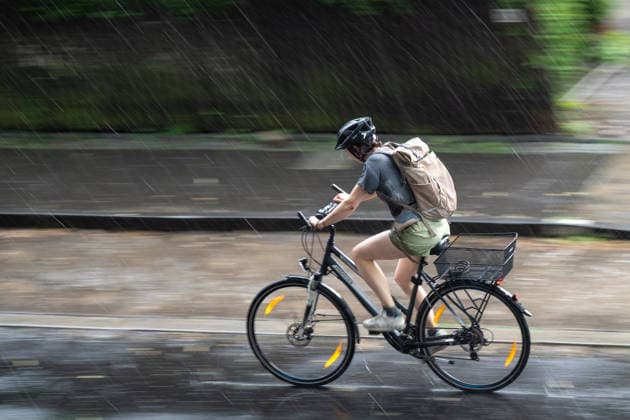 Starkregen in Göttingen 03.08.2026, Göttingen --- Eine Radfahrerin fährt während eines Starkregens durch eine Straße in Göttingen. Göttingen Niedersachsen Deutschland