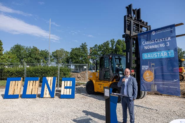 Baustart Cargo ‹Center 3 am Flughafen Nürnberg, Nürnberg, 04.08.2026 Ein Redner spricht am Podium anlässlich des Baustarts für das neue Cargo Center Nürnberg 3 (CCN 3) am Flughafen Nürnberg. Im Hintergrund stehen ein Gabelstapler sowie ein Werbebanner zur Baumaßnahme. Der Ausbau des Cargo-Bereichs reagiert auf die anhaltend hohe Nachfrage nach Logistikflächen. Nürnberg Flughafen Bayern Deutschland