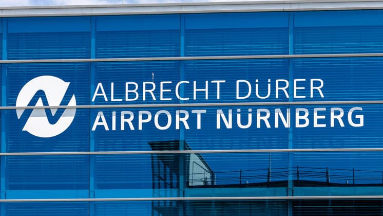 Flughafen Nürnberg, 04.08.2026 Der Schriftzug Albrecht Dürer Airport Nürnberg ist an der Glasfassade des Flughafengebäudes angebracht. Das Logo mit stilisiertem N ist auf der blau getönten Fensterfront zu sehen. Nürnberg Flughafen Bayern Deutschland