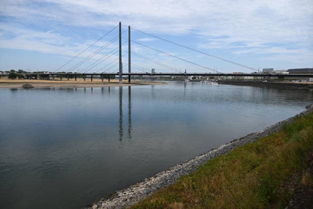 Historisches Niedrigwasser im Rhein, die Wasserschutzpolizei Duesseldorf meldet mit 23cm den niedrigsten in Duesseldorf gemessenen Rheinpegel, Tiefer Wasserstand, steiniges Flussufer, im Hintergrund die Rheinkniebruecke, Duesseldorf, 04.08.2026