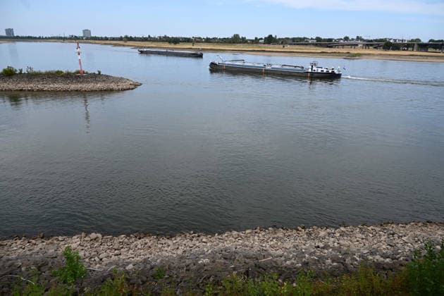 Historisches Niedrigwasser im Rhein, die Wasserschutzpolizei Duesseldorf meldet mit 23cm den niedrigsten in Duesseldorf gemessenen Rheinpegel, Tiefer Wasserstand, steiniges Flussufer, eine weit aufragende rote Ufermarkierung, im Hintergrund begegnen sich zwei Frachtschiffe, Duesseldorf, 04.08.2026
