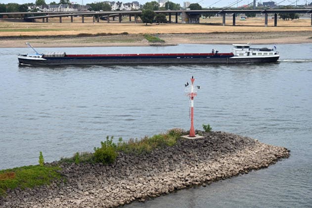 Historisches Niedrigwasser im Rhein, die Wasserschutzpolizei Duesseldorf meldet mit 23cm den niedrigsten in Duesseldorf gemessenen Rheinpegel, Tiefer Wasserstand, steiniges Flussufer, eine weit aufragende rote Ufermarkierung, im Hintergrund ein Frachtschiff, Duesseldorf, 04.08.2026