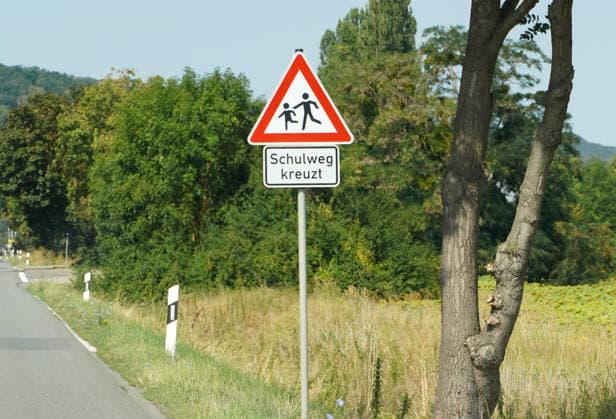 Vorsicht Kinder im Straßenverkehr, Verkehrszeichen mit Zusatzzeichen am Rand einer Landstraße, Schulweg kreuzt, Unfallgefahr, langsam fahren