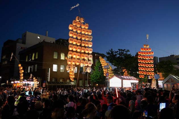 August 5, 2026, Akita, Japan: Visitors look at participants balancing bamboo poles adorned with paper lanterns (kanto) during the Akita Kanto Festival in Akita City. The annual event is one of the Tohoku region s three great festivals, where street performers skillfully balance over 270 towering bamboo poles (with the largest measuring 12 meters and weighing 50 kilograms) adorned with up to 46 candle-lit paper lanterns on their hands, shoulders, and foreheads to the rhythmic chant of dokkoisho. The festival runs from August 3 to 6. Akita Japan - ZUMAm191 20260805_aap_m191_023 Copyright: xRodrigoxReyesxMarinx
