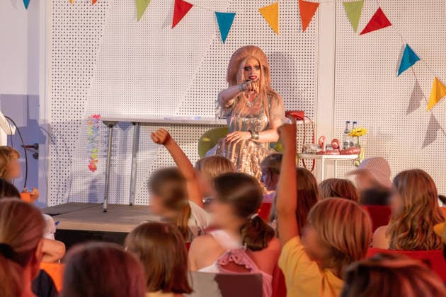 Dragqueen Vicky Voyage bei Kinderbuch-Lesung in der Stadtbücherei Augsburg, draußen vor der Bücherei läuft dagegen ein AfD-naher Protest, Augsburg, 5. August 2026 Deutschland, Augsburg, 5. August 2026, Dragqueen Vicky Voyage bei Kinderbuch-Lesung in der Stadtbücherei Augsburg, Ernst-Reuter-Platz, Mittwochnachmittag ab 15:30 bis 17 Uhr, der AfD-nahe Jugendverein Aljuza demonstriert vor der Stadtbücherei gegen diesen Auftritt, Aljuza Abkürzung für Alternatives Jugendzentrum Augsburg, rechtsextremer Protest, Bayern