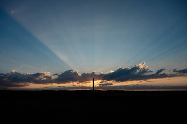 Die Sonne geht hinter dem TK-Elevator Testturm in Rottweil unter. Der Testturm ist dabei als Silhouette im Abendhimmel zu sehen. Rottweil Baden-Württemberg Deutschland