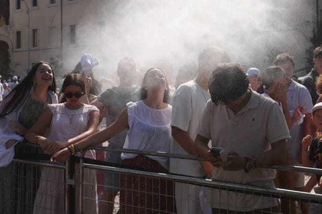 IPA87273180 - Assisi, Italy, August 6, 2026: Young people cool off under the water jets because of the intense heat. The Holy Father Leo XIV meets with young people participating in the GO! Franciscan Youth Meeting 2026 at the Basilica of Santa Maria degli Angeli in Assisi. The event brings together young people from various countries for a time of prayer, reflection, and sharing inspired by Franciscan spirituality.  Copyright: xmarcoxiacobuccix xmarcoxiacobuccix 87273180