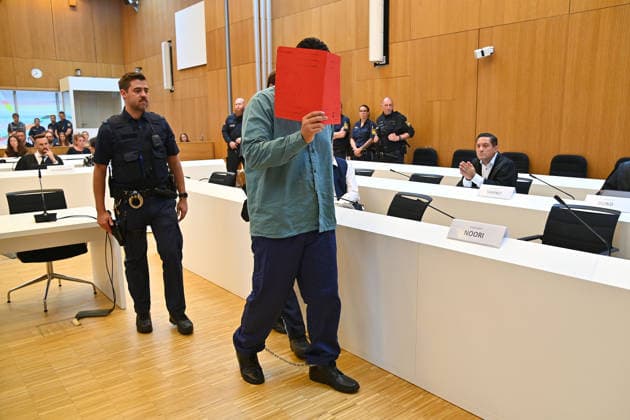 Der Angeklagte wird von Justizbeamten in den Verhandlungssaal gefuehrt. Urteil im Strafverfahren gegen Farhad Noori wegen Mordes u.a.(Seidlstrasse) am 06.08.2026 vor dem Oberlandesgericht Muenchen