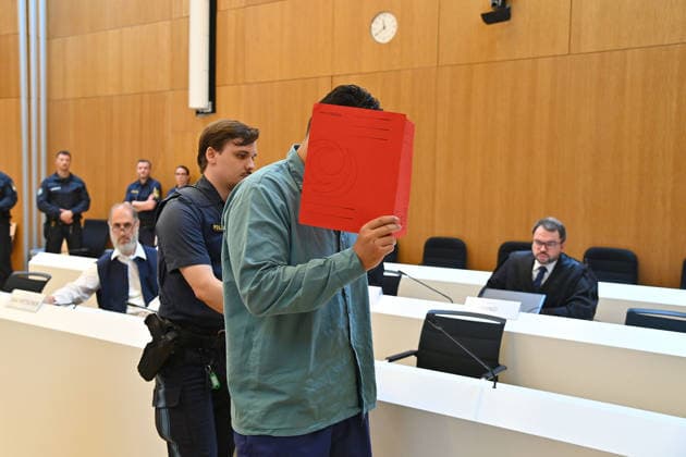 Der Angeklagte wird von Justizbeamten in den Verhandlungssaal gefuehrt. Urteil im Strafverfahren gegen Farhad Noori wegen Mordes u.a.(Seidlstrasse) am 06.08.2026 vor dem Oberlandesgericht Muenchen
