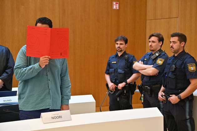 Der Angeklagte im Verhandlungssaal, verbirgt sein Gesicht hinter einem Schnellhefter. Urteil im Strafverfahren gegen Farhad Noori wegen Mordes u.a.(Seidlstrasse) am 06.08.2026 vor dem Oberlandesgericht Muenchen