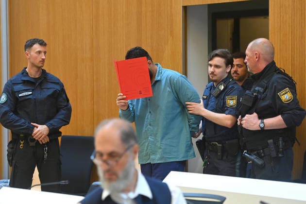 Der Angeklagte wird von Justizbeamten in den Verhandlungssaal gefuehrt. Urteil im Strafverfahren gegen Farhad Noori wegen Mordes u.a.(Seidlstrasse) am 06.08.2026 vor dem Oberlandesgericht Muenchen