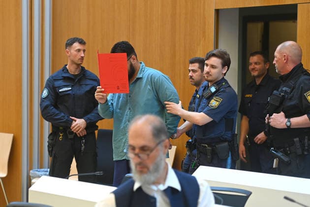 Der Angeklagte wird von Justizbeamten in den Verhandlungssaal gefuehrt. Urteil im Strafverfahren gegen Farhad Noori wegen Mordes u.a.(Seidlstrasse) am 06.08.2026 vor dem Oberlandesgericht Muenchen