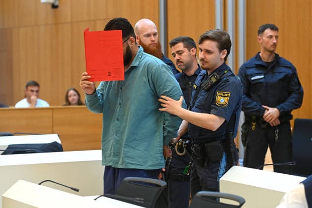 Der Angeklagte wird von Justizbeamten in den Verhandlungssaal gefuehrt. Urteil im Strafverfahren gegen Farhad Noori wegen Mordes u.a.(Seidlstrasse) am 06.08.2026 vor dem Oberlandesgericht Muenchen