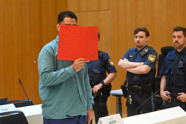 Der Angeklagte im Verhandlungssaal, verbirgt sein Gesicht hinter einem Schnellhefter. Urteil im Strafverfahren gegen Farhad Noori wegen Mordes u.a.(Seidlstrasse) am 06.08.2026 vor dem Oberlandesgericht Muenchen