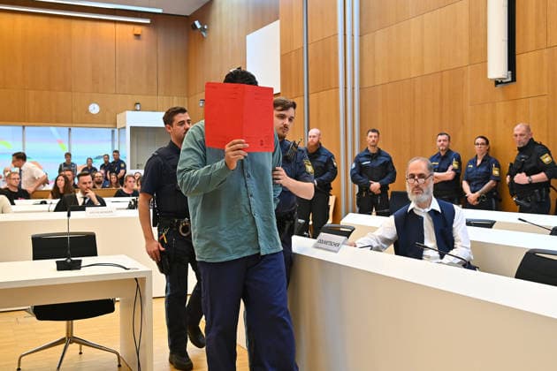 Der Angeklagte wird von Justizbeamten in den Verhandlungssaal gefuehrt. Urteil im Strafverfahren gegen Farhad Noori wegen Mordes u.a.(Seidlstrasse) am 06.08.2026 vor dem Oberlandesgericht Muenchen