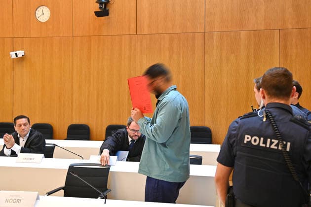 Der Angeklagte im Verhandlungssaal, verbirgt sein Gesicht hinter einem Schnellhefter. Urteil im Strafverfahren gegen Farhad Noori wegen Mordes u.a.(Seidlstrasse) am 06.08.2026 vor dem Oberlandesgericht Muenchen