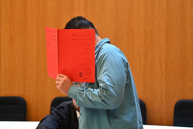 Der Angeklagte im Verhandlungssaal, verbirgt sein Gesicht hinter einem Schnellhefter. Urteil im Strafverfahren gegen Farhad Noori wegen Mordes u.a.(Seidlstrasse) am 06.08.2026 vor dem Oberlandesgericht Muenchen