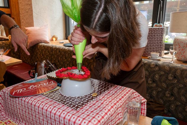 Muenchen, Pressekonferenz zur Wirtshauswiesn 2027 beim Spoeckmeier, eine Mitarbeiterin vom Cafe Luitpold verzieren und Lebkuchenherzen mit dem gewuenschten Schrifzug