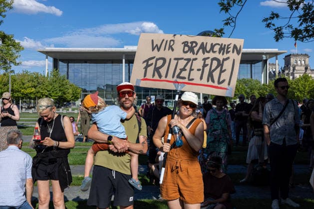 Fridays for Future Berlin - Hitzedemo. Deutschland, Berlin am 6. August 2026: Eine Familie (Eltern und ein kleines Kind) Halten ein Schild Hoch Wir brauchen Fritze-Frei . Vor dem Kanzleramt protestieren Klimaaktivistinnen und Klimaaktivisten unter dem Motto Klimakrise eskaliert, Kanzler schweigt?!. Sie verlangen verstärkte Klimaschutzmaßnahmen, einen schnellen politischen Hitzeschutz sowie einen konsequenten Ausstieg aus fossilen Energien.