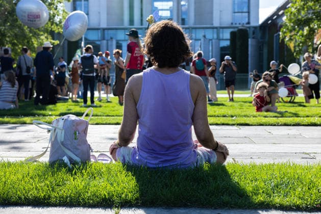 Fridays for Future Berlin - Hitzedemo. Deutschland, Berlin am 6. August 2026: Ein Mann in Yoga Position vorm Demo. Vor dem Kanzleramt protestieren Klimaaktivistinnen und Klimaaktivisten unter dem Motto Klimakrise eskaliert, Kanzler schweigt?!. Sie verlangen verstärkte Klimaschutzmaßnahmen, einen schnellen politischen Hitzeschutz sowie einen konsequenten Ausstieg aus fossilen Energien.