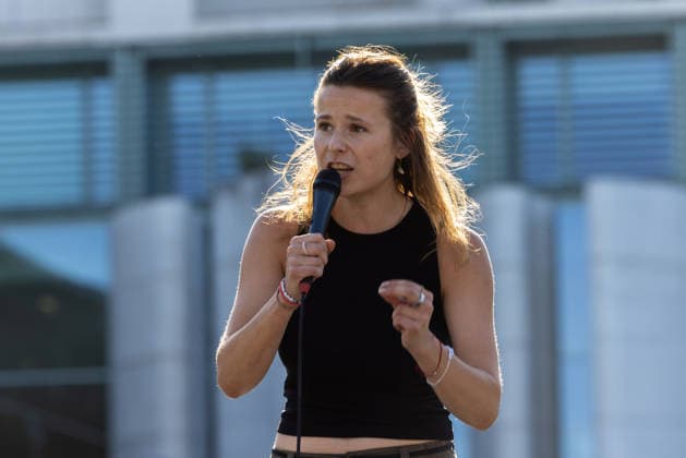 Fridays for Future Berlin - Hitzedemo. Deutschland, Berlin am 6. August 2026: Luisa Neubauer spricht auf der Bühne vor dem Kanzleramt zu den Demonstrationsteilnehmenden. Vor dem Kanzleramt protestieren Klimaaktivistinnen und Klimaaktivisten unter dem Motto Klimakrise eskaliert, Kanzler schweigt?!. Sie verlangen verstärkte Klimaschutzmaßnahmen, einen schnellen politischen Hitzeschutz sowie einen konsequenten Ausstieg aus fossilen Energien.