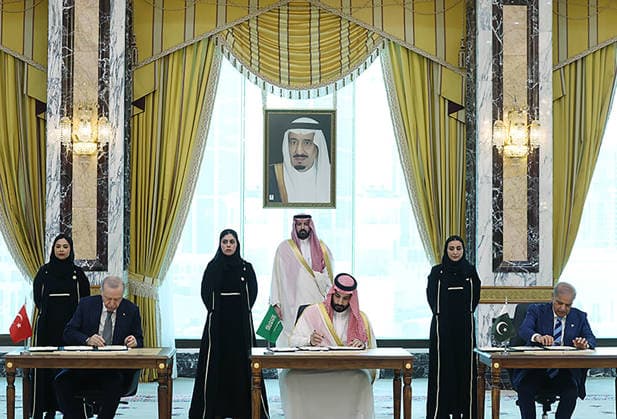 Turkish President Recep Tayyip Erdogan (L), Saudi Crown Prince Mohammed bin Salman (C), and Pakistani Prime Minister Shehbaz Sharif (R) sign a trilateral defense agreement in Mecca, Saudi Arabia, on Friday on August 7, 2026.  SAU2026080705 TurkishxPresidencyxOffice