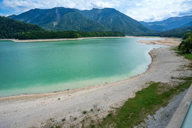 Der Wasserspiegel des Sylvensteinspeichers ist wegen anhaltender Trockenheit deutlich gesunken, breite Uferstreifen sind trocken gefallen, das Niedrigwasser sorgt für breite Kiesflächen, Bayerische Alpen, Lenggries, 7. August 2026 Deutschland, Lenggries-Fall, 7. August 2026, breite Kiesflächen am Ufer des Sylvensteinspeichers, die anhaltende Trockenheit hat den Wasserspiegel des Sylvensteinspeichers deutlich sinken lassen, breite Uferstreifen sind trocken gefallen, Niedrigwasser sorgt für einen breiten Kiesstrand, künstlicher Speichersee in den Bayerischen Voralpen bei Lenggries, Wasserspeicher zur Regulierung der Isar, Hochsommer, heißer Sommertag, Freitagnachmittag, Landkreis Bad Tölz-Wolfratshausen, Oberbayern, Sommer, Bayern