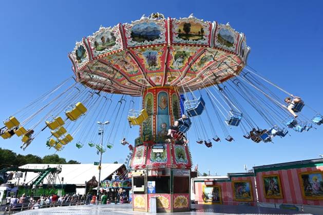 Nach dem Oktoberfest ist das Gäubodenvolksfest in Straubing das bekannteste Volksfest in Bayern. Der Vergnügungspark umfasst rund 130 Fahrgeschäfte. Kirmes-Besucher beim Jahrmarkt auf dem Rummel. Foto: Stranninger, Wellenflug - Kettenkarussell.