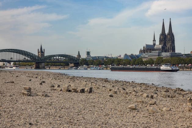 Sommer im Rheinland. Blick auf den Rhein bei Koeln (Köln) - Deutz. Der Rhein in Koeln (Köln) fuehrt (führt) Niedrigwasser aufgrund anhaltender Trockenheit. Im Hintergrund die Hohenzollernbruecke (Hohenzollernbrücke) (links) und der Koelner (Kölner) Dom (rechts). Ein Schiff ist unterwegs. Sommer im Rheinland am 09.08.2026 in Koeln (Köln) Deutschland.