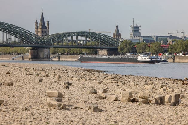 Sommer im Rheinland. Blick auf den Rhein bei Koeln (Köln) - Deutz. Der Rhein in Koeln (Köln) fuehrt (führt) Niedrigwasser aufgrund anhaltender Trockenheit. Im Hintergrund die Hohenzollernbruecke (Hohenzollernbrücke). Ein Schiff ist unterwegs. Sommer im Rheinland am 09.08.2026 in Koeln (Köln) Deutschland.